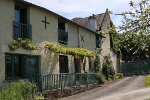 a house with a green fence in front of it at Le Clos du Noisillet in Cinais