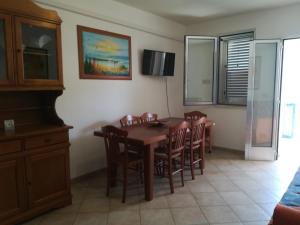 una sala da pranzo con tavolo e sedie in legno di House Pedone a Otranto