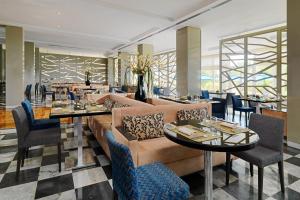 un restaurant avec des canapés, des tables et des chaises dans l'établissement Sheraton Tunis Hotel, à Tunis