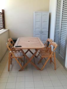 un tavolo in legno e 2 sedie in una stanza di House Pedone a Otranto Altre 9 foto