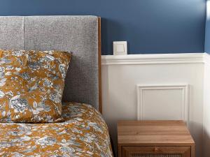 a bed with a pillow and a wooden night stand at Appartement Richard Merrill, en plein centre, 4 pers in Sainte-Mère-Église