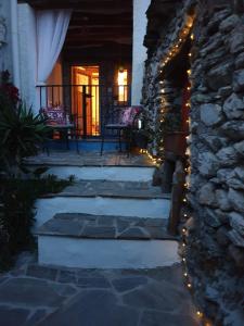 a patio with christmas lights and a stone wall at Casa Carrie in Válor