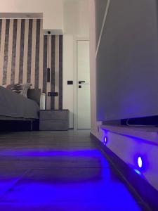 um quarto com uma cama com luzes azuis em La Fenice 40 em Numana