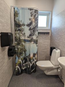 a bathroom with a toilet and a shower curtain at Vårhaga Vandrarhem in Sjuntorp