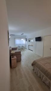 Un dormitorio con una cama, un sofá y una mesa. en Monoambiente centro pinamar, en Pinamar