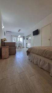 Un dormitorio con una cama, un sofá y un televisor. en Monoambiente centro pinamar, en Pinamar 2 fotos más