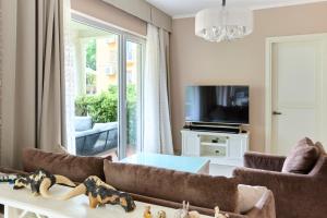 a living room with a couch and a tv at GREEN HILL Aparts with POOL & SCENIC VIEW in Gornji Orahovac +29 photos