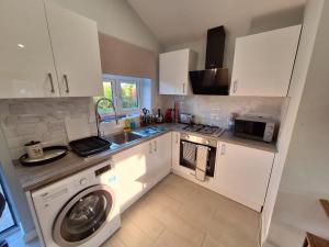 una cucina con lavatrice di Stylish studio flat with private patio and free on-street parking a Bournemouth