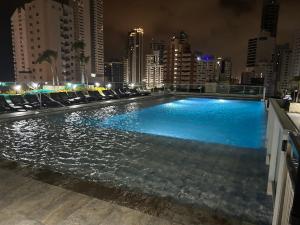 a large swimming pool in a city at night at INFiNiTUM LUXURY in Cartagena de Indias