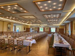 WallseeGasthof Hehenberger的宴会厅配有长桌子和椅子