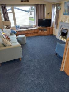 ein Wohnzimmer mit einem Sofa und einem TV in der Unterkunft Captain's Quarters in Brixham