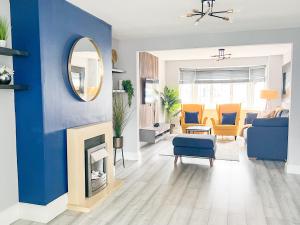 a living room with a blue wall and a mirror at Beautiful Newly Renovated House in Rainham Essex in Rainham
