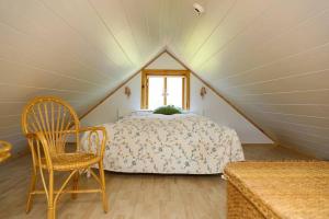 a bedroom with a bed and a chair in a attic at Charming Cabin close to Akureyri in Halllandsnes