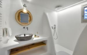a bathroom with a sink and a mirror at Beachfront Villa Kalafatis by Aesthia Estate in Kalafatis +18 photos