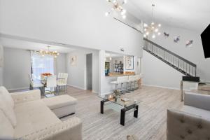 a living room with white furniture and a staircase at Aster Equestrian Florida Home with Heated Pool/SPA in Wellington