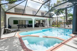 a large swimming pool in a yard with a house at Aster Equestrian Florida Home with Heated Pool/SPA in Wellington