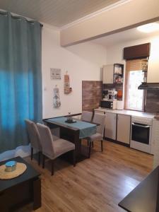 eine Küche und ein Wohnzimmer mit einem Tisch und Stühlen in der Unterkunft Apartman Envi in Opatija