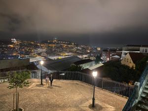 2 personnes debout au-dessus d'un bâtiment la nuit dans l'établissement Estudio T41, à Lisbonne