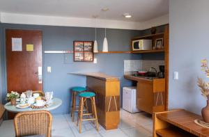 cocina con encimera y mesa con taburetes en Flat Residencial Meireles Fortaleza, en Fortaleza