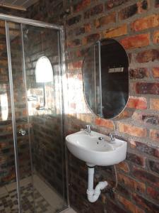 a bathroom with a sink and a glass shower at Megs Accommodation in Kamieskroon