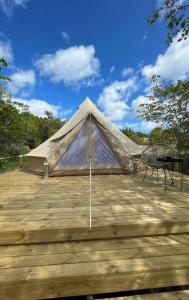 une tente sur une terrasse en bois avec une table dans l'établissement Glamping Tent Mariehamn, à Mariehamn