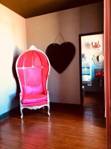 ナルボンヌにあるChâteau de La Pradeの壁にハートを掛けた部屋のピンクの椅子