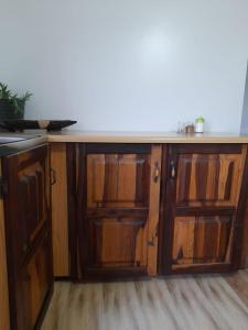 a wooden cabinet with glass doors and a counter at Megs Accommodation in Kamieskroon