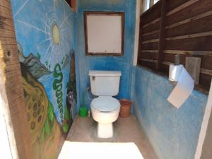 马祖特hostal pakal的浴室设有卫生间,墙上挂有绘画作品