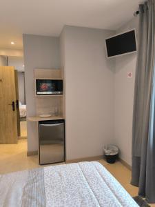 a bedroom with a bed and a desk with a television at HABITACION CON HERMOSAS VISTAS A BILBAO in Bilbao