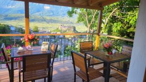 a porch with two tables and chairs with a view at Guest House Hasko in Gjirokastër