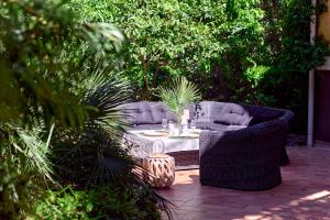 a patio with wicker chairs and a table in a garden at GREEN HILL Aparts with POOL & SCENIC VIEW in Gornji Orahovac