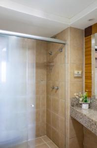 y baño con ducha y puerta de cristal. en Flat Residencial Meireles Fortaleza, en Fortaleza