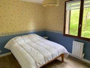 ein Schlafzimmer mit einem weißen Bett in einem Zimmer mit einem Fenster in der Unterkunft Agréable T2 en rez de jardin à 2 pas du plan d'eau in Embrun