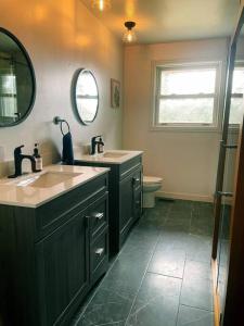 Exclusive Waterfront Cottage في Combermere: حمام مع حوض و مرآة و مرحاض +30 صورة