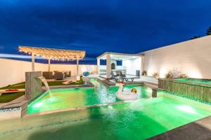 a pool with a swan in a backyard at night at Casa de las Sirenas, Las Conchas, Private Pool in Puerto Peñasco