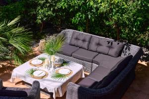 a patio with a couch and a table and chairs at GREEN HILL Aparts with POOL & SCENIC VIEW in Gornji Orahovac