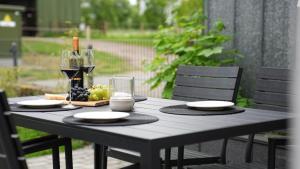 a black table with wine glasses and a plate of food at Modernes Ferienhaus im Eidertal in Delve