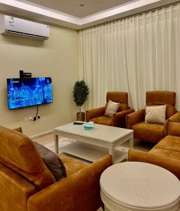 Il comprend un salon doté d'un mobilier en cuir et d'une télévision. dans l'établissement شقة جديدة وفاخرة بالقرب من الحرم ., à Sīdī Ḩamzah