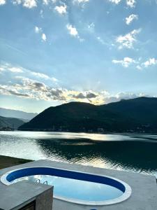 a swimming pool next to a body of water at Rustic Heaven Ostrožac Cottage houses in Jablanica