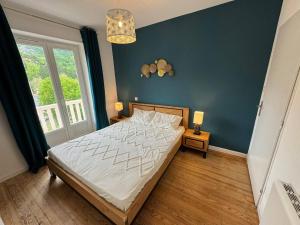 una camera da letto con un letto e una parete blu di Le Grillon ad Ax-les-Thermes Altre 46 foto