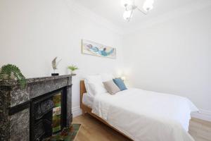 een slaapkamer met 2 bedden en een open haard bij Cosy Federation Apartment Kirribilli 2 Bedroom #2 in Sydney