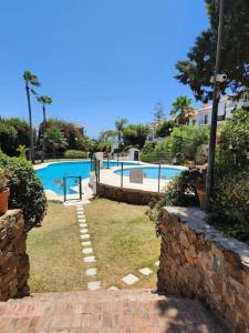una piscina in un resort con un muro di mattoni di Grande maison familiale - Mer et Golf a Torre de Benagalbón