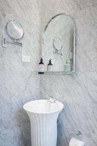 La salle de bains blanche est pourvue d'un lavabo et d'un miroir. dans l'établissement Cosy Federation Apartment Kirribilli 2 Bedroom #2, à Sydney