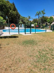 una piscina con un anello arancione in un parco di Grande maison familiale - Mer et Golf a Torre de Benagalbón