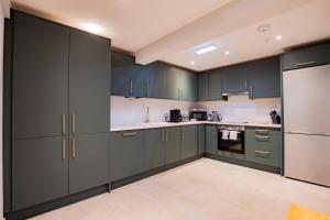 eine Küche mit grünen Schränken und weißen Geräten in der Unterkunft The Large Group House -Sleeps 21 in Dublin