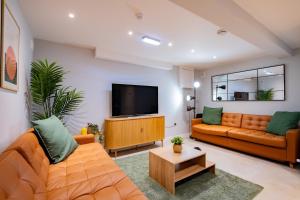 sala de estar con muebles de color naranja y TV de pantalla plana. en The Large Group House -Sleeps 21, en Dublín