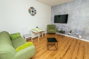 a living room with a green couch and a table at Dalomar Apartment in Biograd na Moru