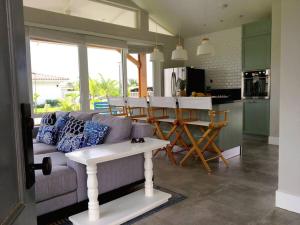 a living room with a couch and a table in a kitchen at Villa Ocean Pearl Venao in Playa Venao