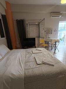 um quarto com uma cama com duas toalhas em Cozy apartment in the center of Aighion Achaia - ground floor - ισόγειο στουντιο em Aigio