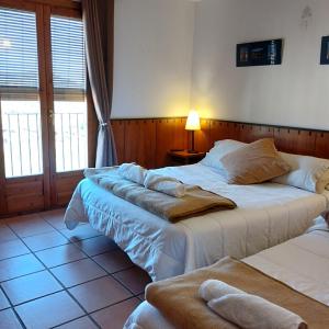 1 dormitorio con 2 camas y toallas. en Hostal Tastavins en Peñarroya de Tastavins